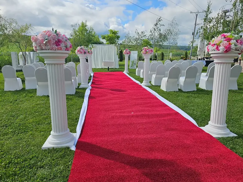 Covor roșu și coloane florale pentru ceremonia în grădină